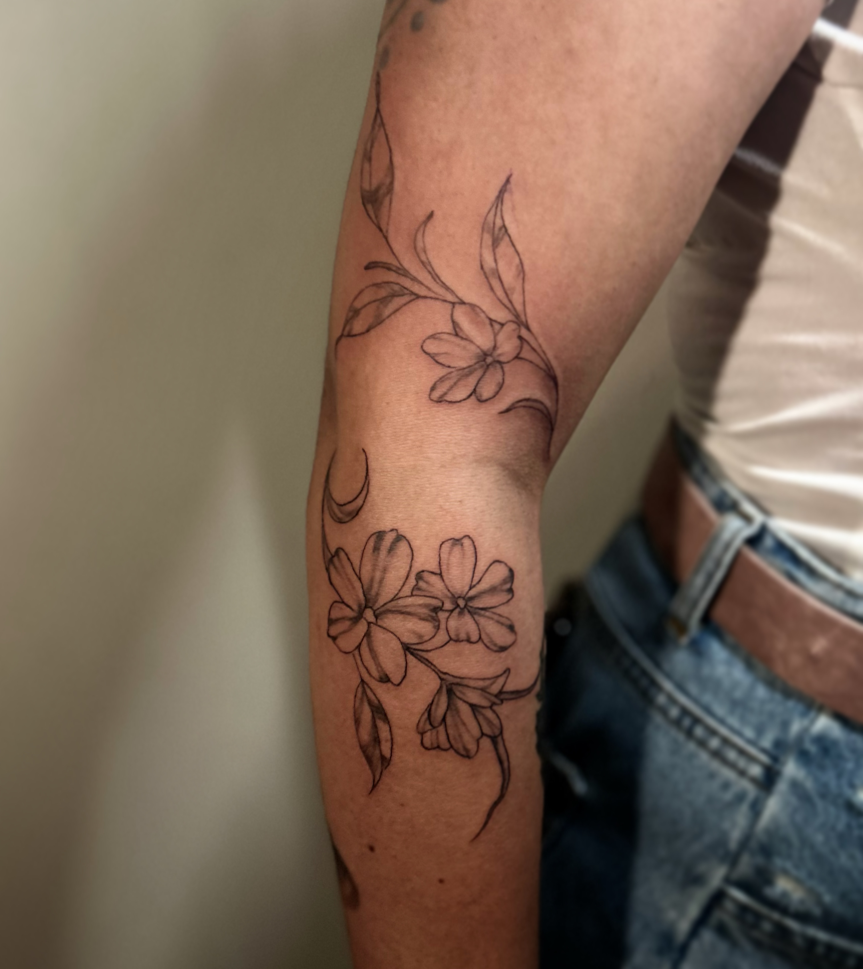 Delicate floral linework flowing along the arm