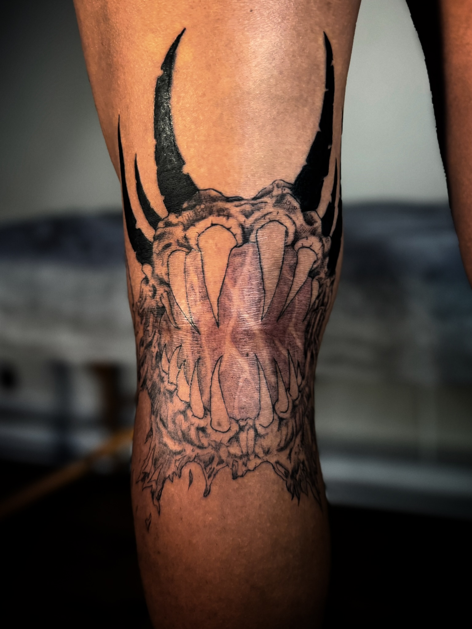Dark horned skull composition on the leg